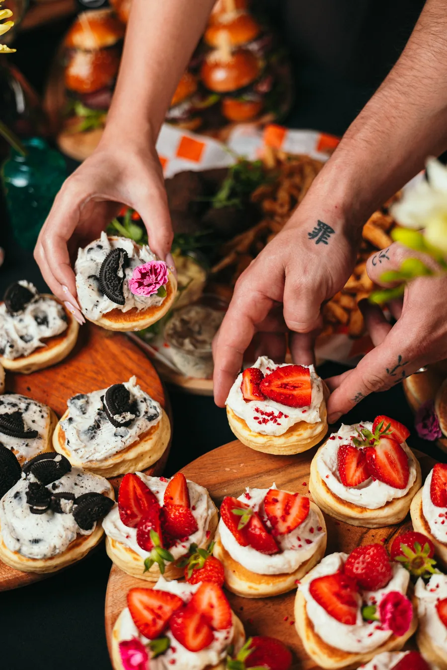 Mini pancakes z kremem, Oreo i truskawkami na drewnianych deskach